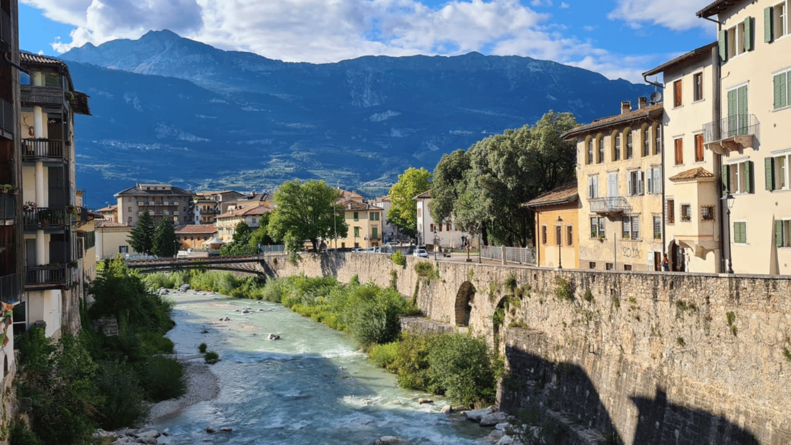 Bergdorf im Trentino mit historischen Häusern am Fluss, zeigt regionale Vielfalt und die Bedeutung von Eigentum in Italien