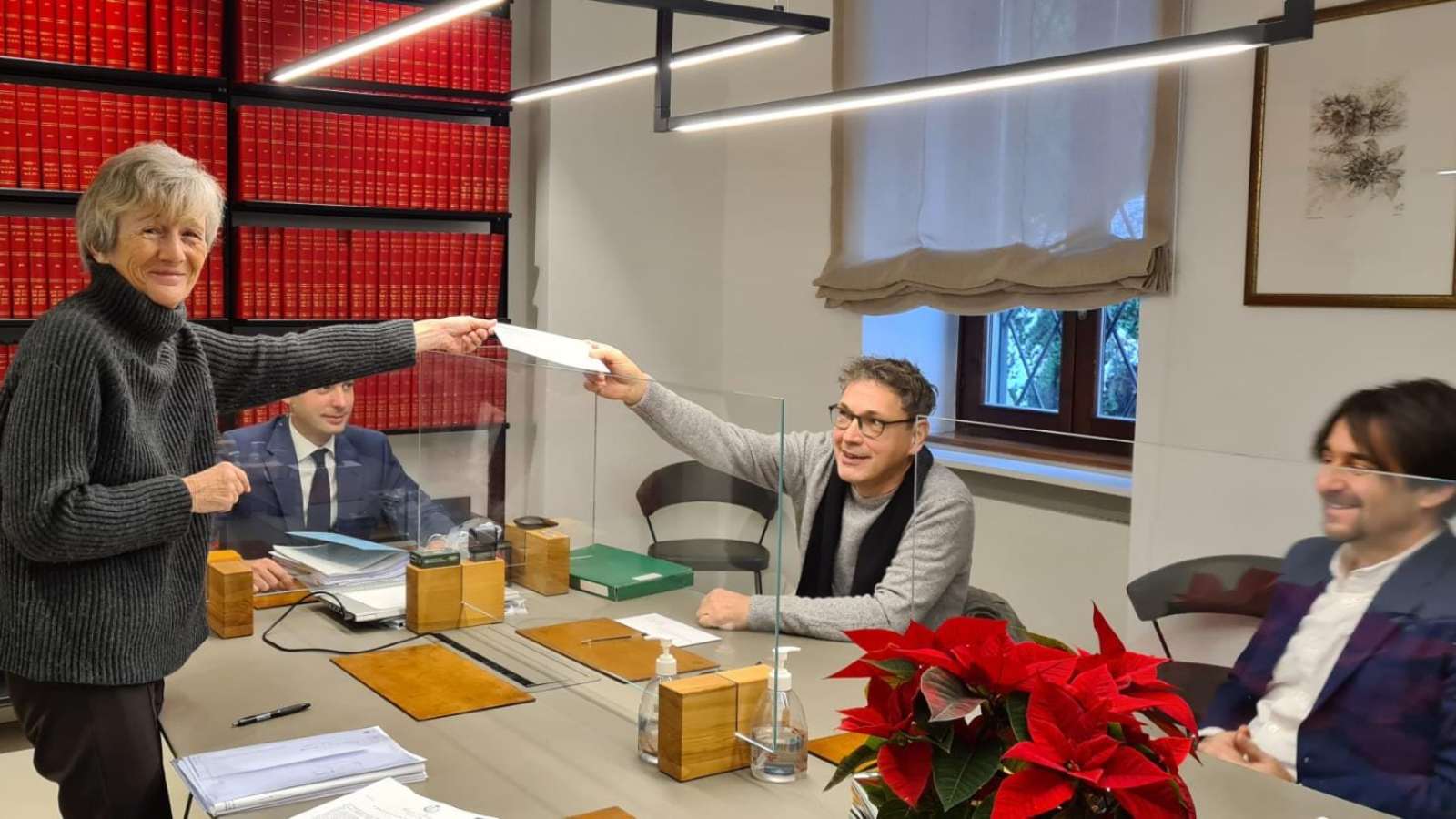 Gitta Eckl-Reinisch überreicht den unterschriebenen Kaufvertrag bei ihrem eigenen Immobilienkauf in Italien